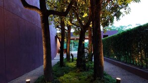 A pathway lined with trees and illuminated by small lights, leading to a building entrance. - The Glory River Kwai Hotel (Kanchanaburi)