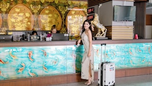 A reception desk with a decorative fish mural, a digital clock, and a Wi-Fi sign. - Satit Grand View Hotel (Sadao)