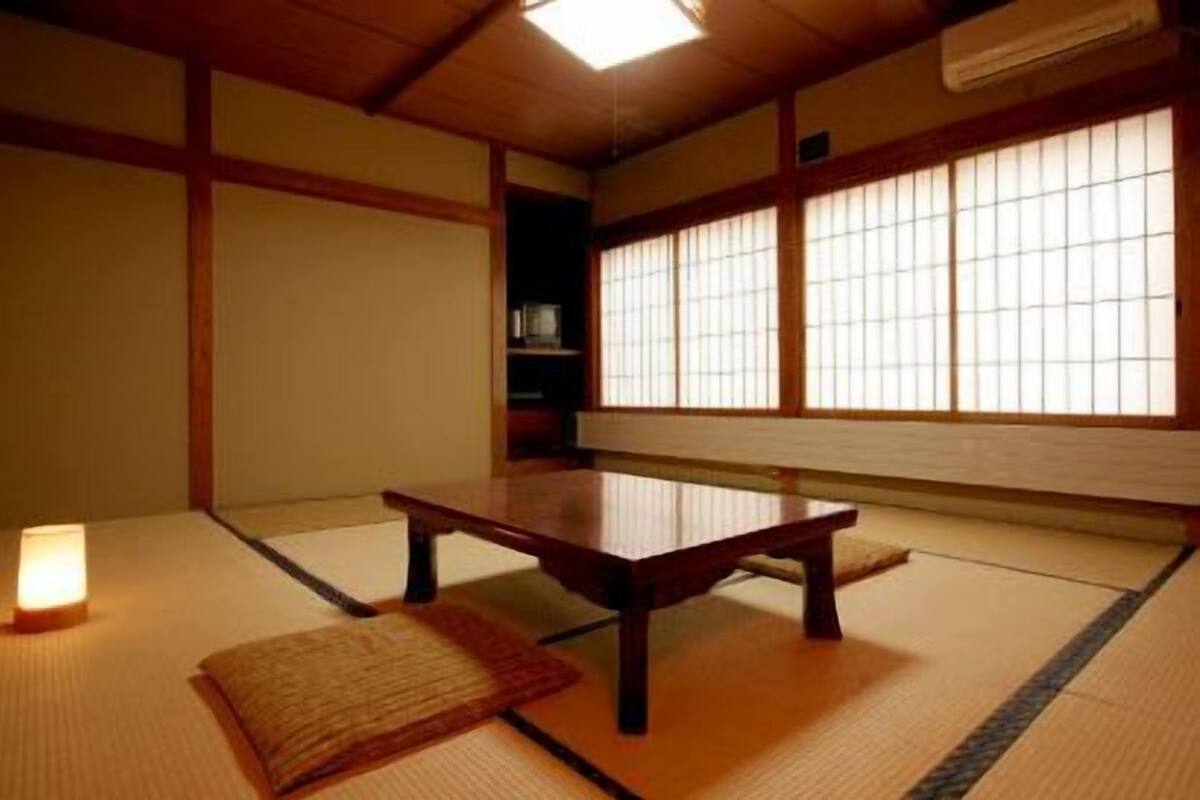 Perinteinen japanilainen huone, jossa on tatamimatto, matala puupöytä ja liukuvat shoji-ovet.