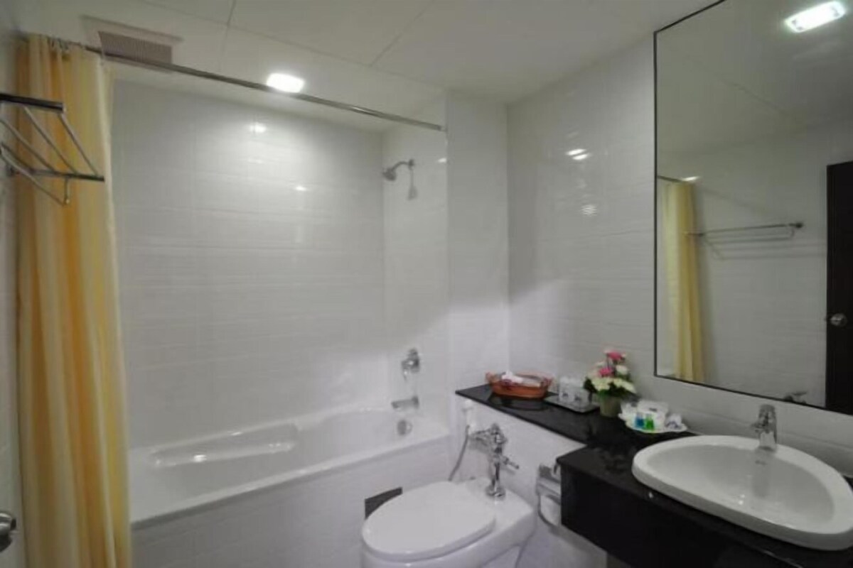A bathroom with a bathtub, toilet, sink, and mirror.