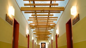 A corridor with wooden slats overhead and doors on either side.
