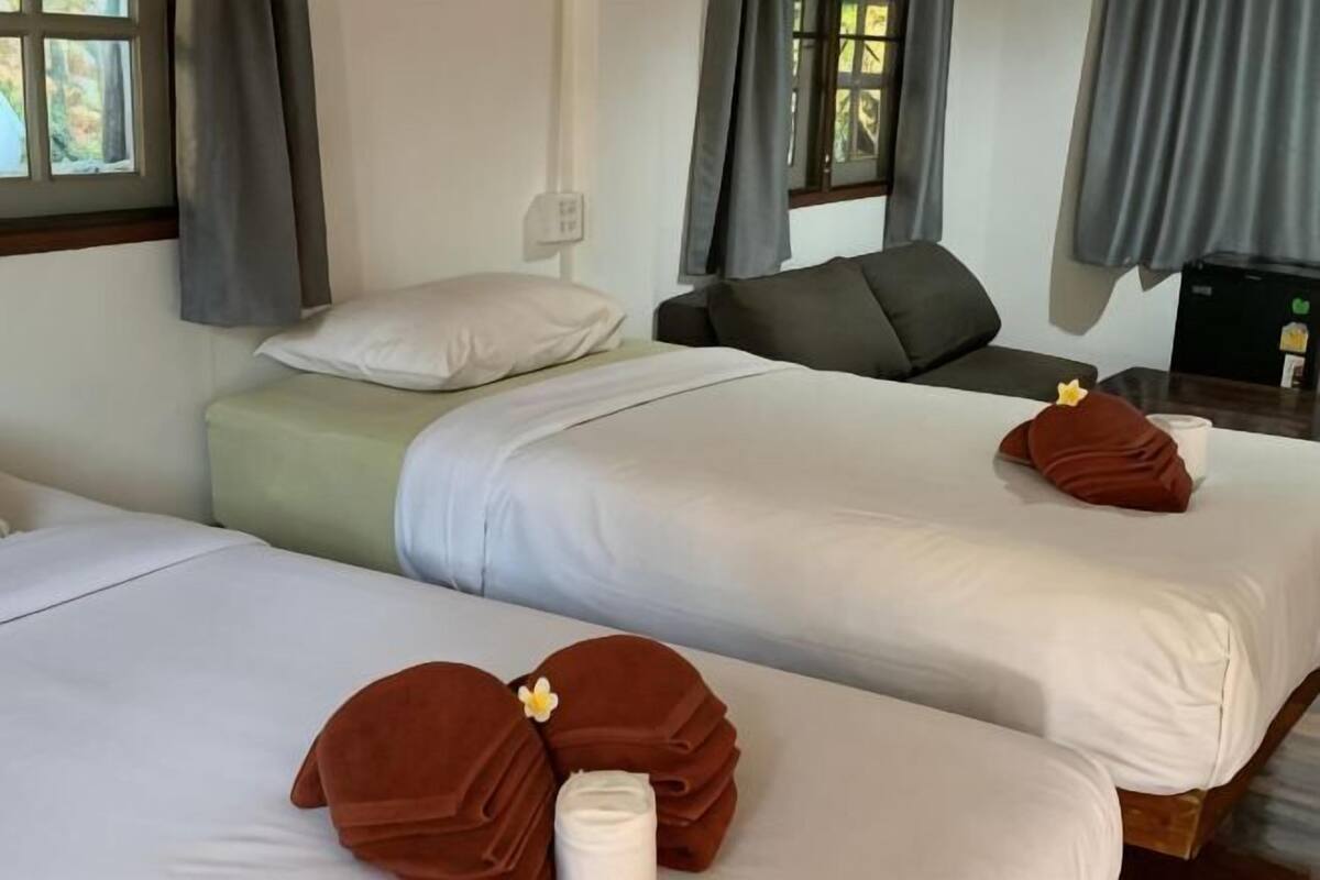 Habitación de hotel con dos camas, un sofá y un escritorio.