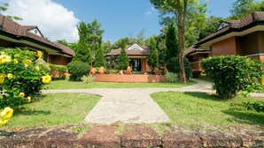 A traditional-style building with a central entrance, surrounded by well-maintained gardens and pathways. - Forra Hill Resort (Mueang Loei)