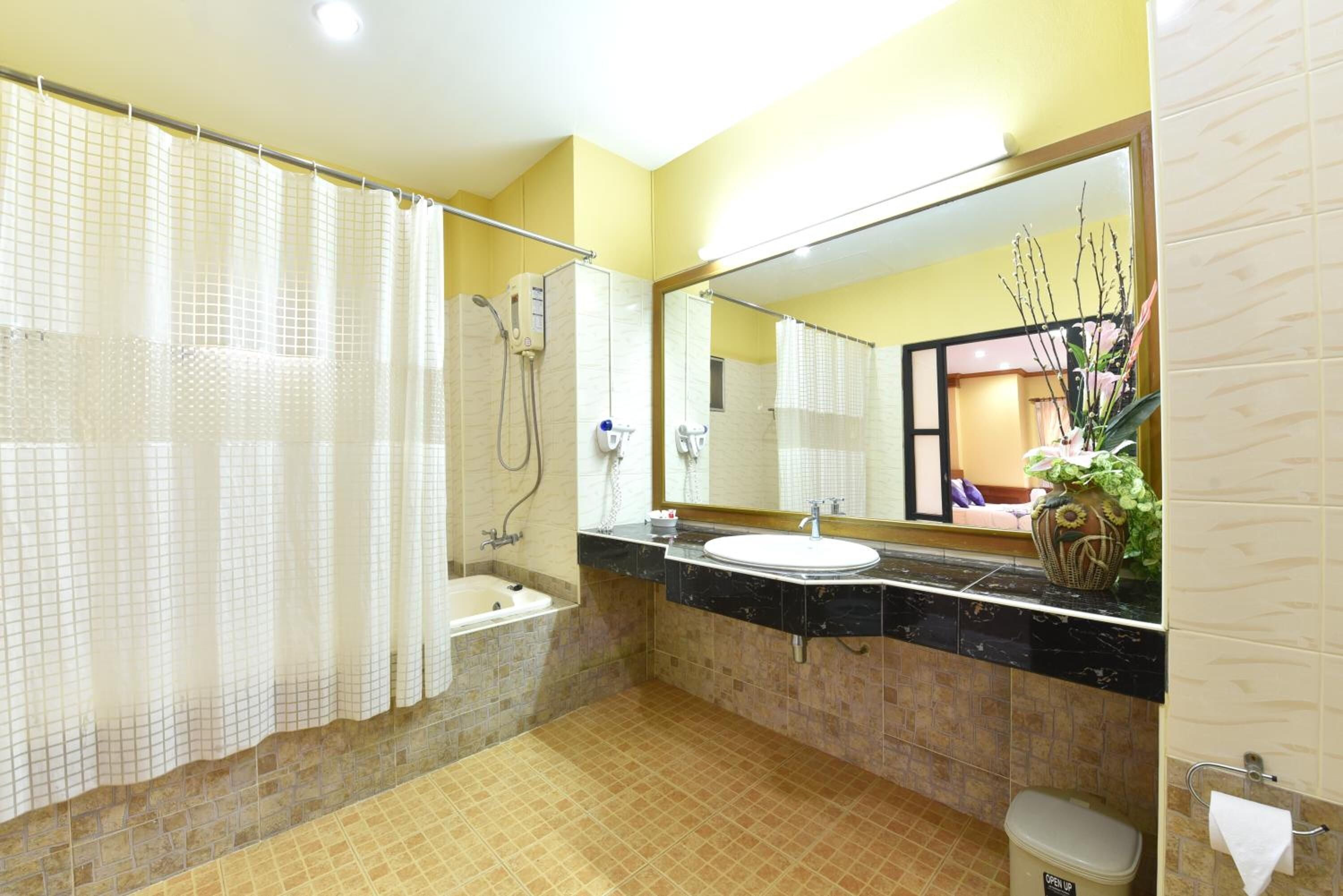 A bathroom with a bathtub, a sink, a toilet, a shower, and a mirror.