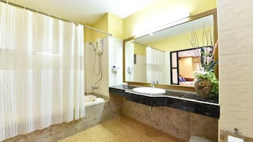 A bathroom with a bathtub, a sink, a toilet, a shower, and a mirror.