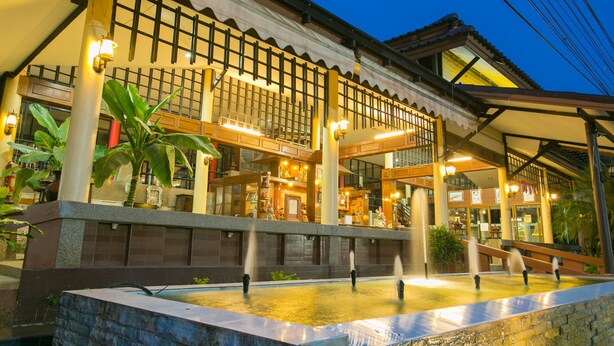 A traditional building with a water feature in front, large windows, and a covered area with seating. - Forra Hill Resort (Mueang Loei)