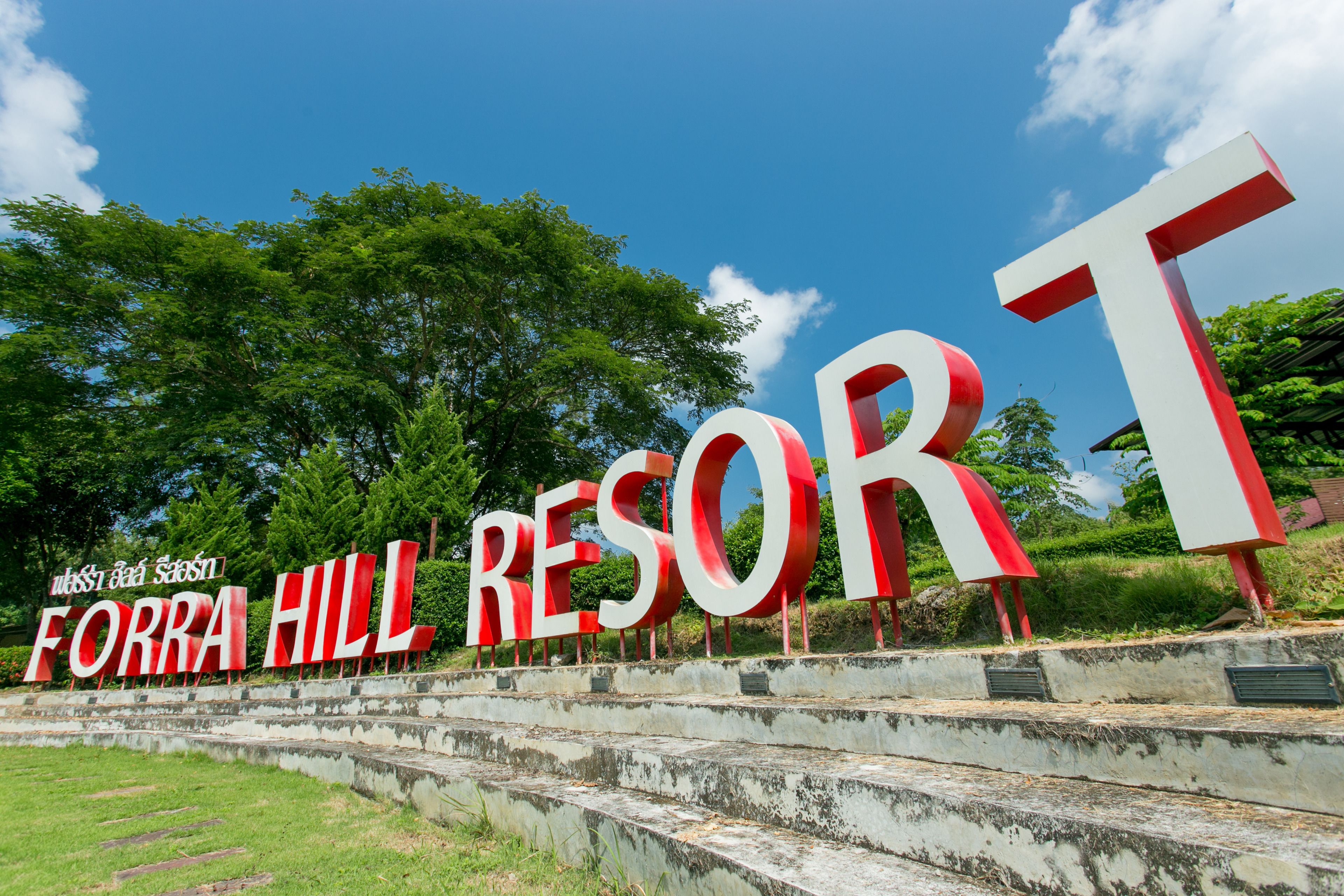 Ein großes Schild für das Forra Hill Resort, mit Treppen, die zu ihm hinaufführen.