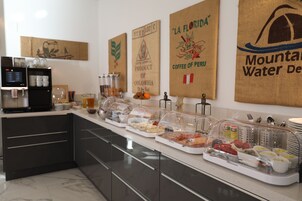 Montaje de bufé con diversos alimentos y una estación de café.