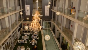 Een meerlaags atrium met een centraal kroonluchter, een eetgedeelte en een fontein.