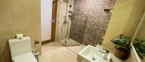 Un baño con inodoro, ducha y lavabo.