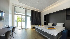 Quarto de hotel moderno com cama, escrivaninha e cadeira.