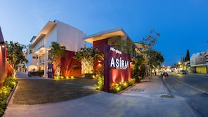 Un edificio moderno con un letrero llamativo del hotel ASIRA Boutique.