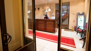 A reception area with a wooden desk, a red carpet, and a Pepsi refrigerator. - Hotel Rina Cerbul (Sinaia)