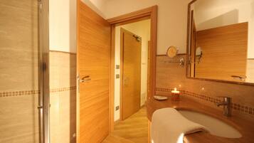 A bathroom with a wooden vanity, a sink, a mirror, and a shower.