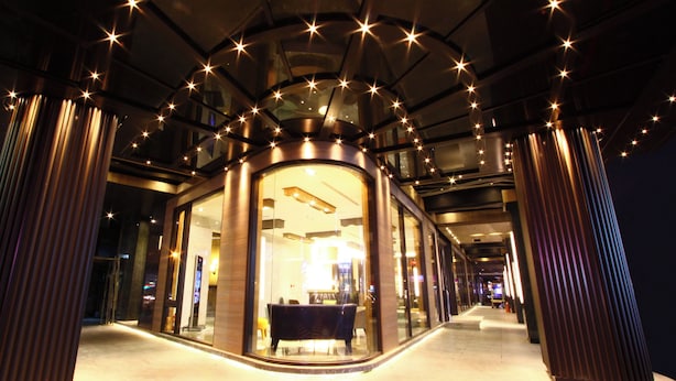 A modern hotel corridor with glass walls, a central seating area, and a starry ceiling. - GOGO HOTEL 38 (Taichung)