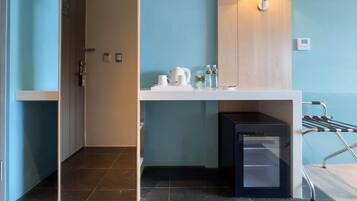 A modern bathroom with a shower, a sink with toiletries, and a towel rack.