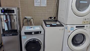 Un área de lavandería con una secadora Panasonic, una lavadora Whirlpool y un enfriador de agua Aquatek.