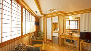 A traditional Japanese-style room with tatami flooring, a low wooden desk, a television, and a large shoji screen window. - Silken Hotel (Taipei)