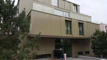 Un edificio moderno con fachada texturizada, ventanas grandes y techo plano.