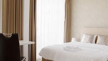 Una habitación de hotel con cama, escritorio y silla.