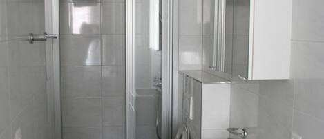 A modern bathroom with a shower, toilet, and vanity.