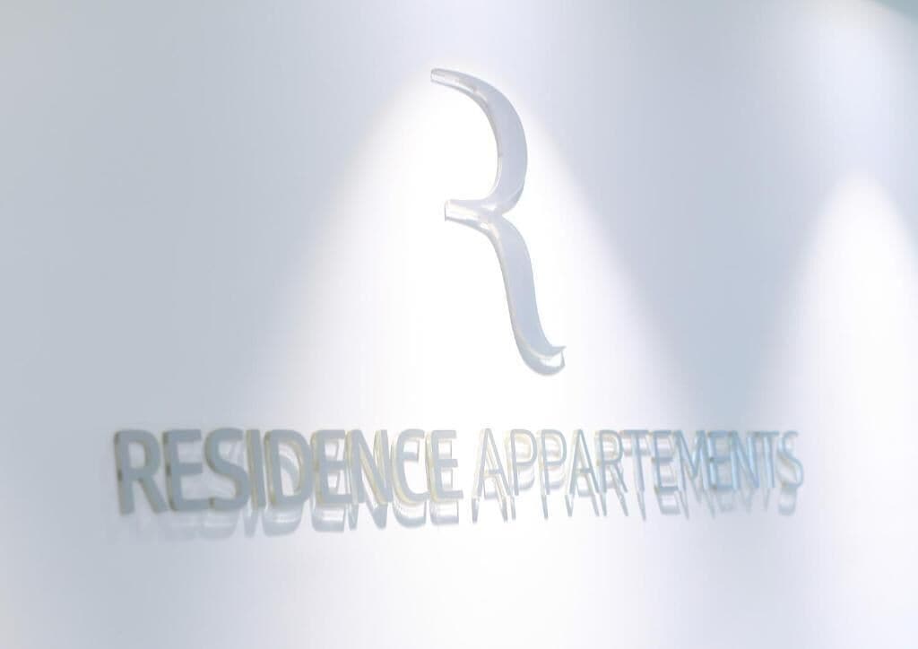 A logo with a stylized 'R' and the text 'RESIDENCE APARTMENTS'.