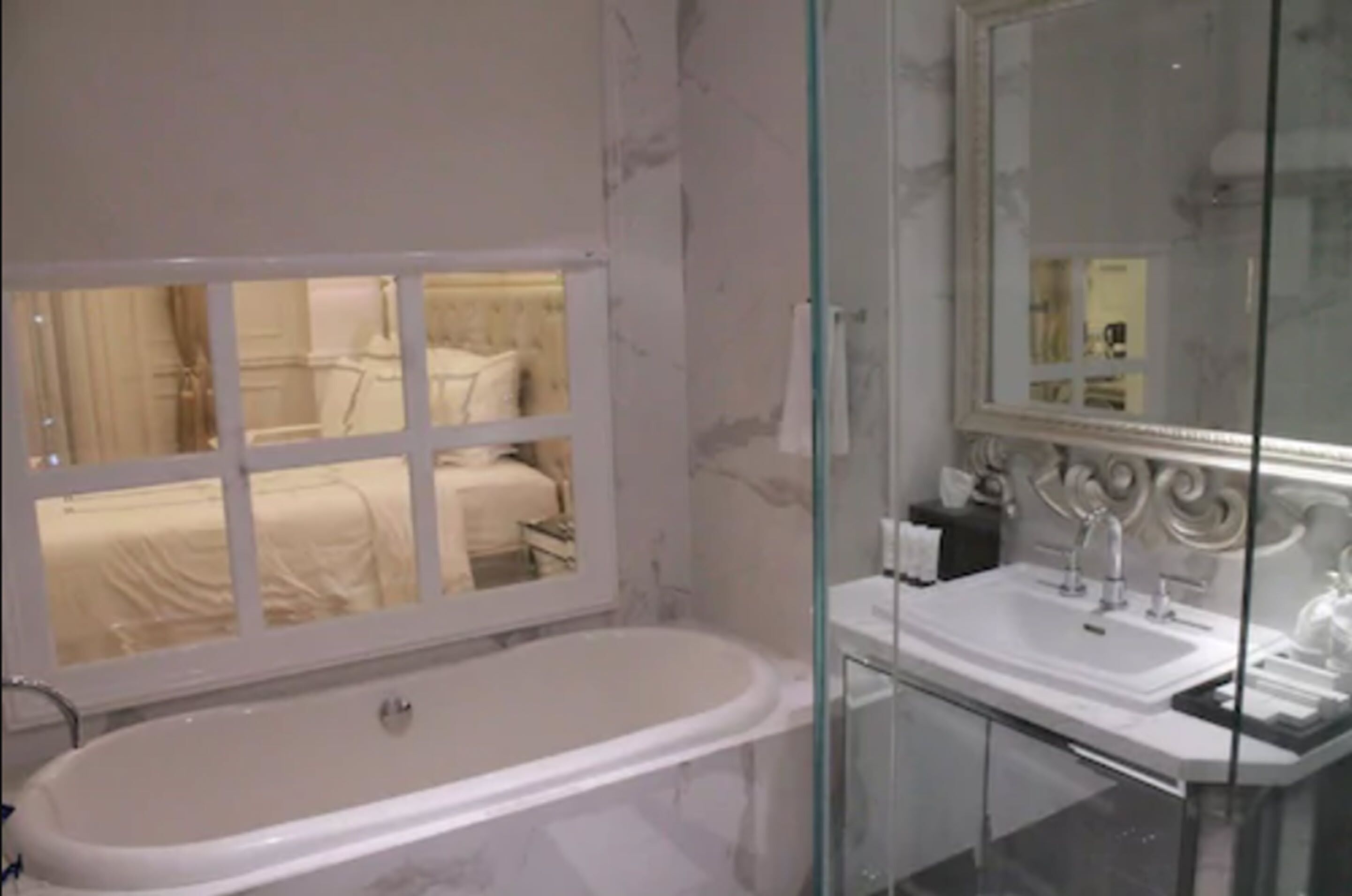 A modern bathroom with a large bathtub, a glass-enclosed shower, and a vanity with a mirror.