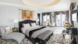 A luxurious bedroom with a large bed, a chaise lounge, a vanity with a mirror, and a tripod. - Lafayette Boutique Hotel Yogyakarta (Depok)