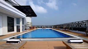 A swimming pool with lounge chairs and a covered area. - Lafayette Boutique Hotel Yogyakarta (Depok)