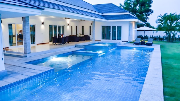 A modern house with a swimming pool, outdoor seating, and a covered patio area. - Tulip House Pool Villa Hua Hin (Cha-am)