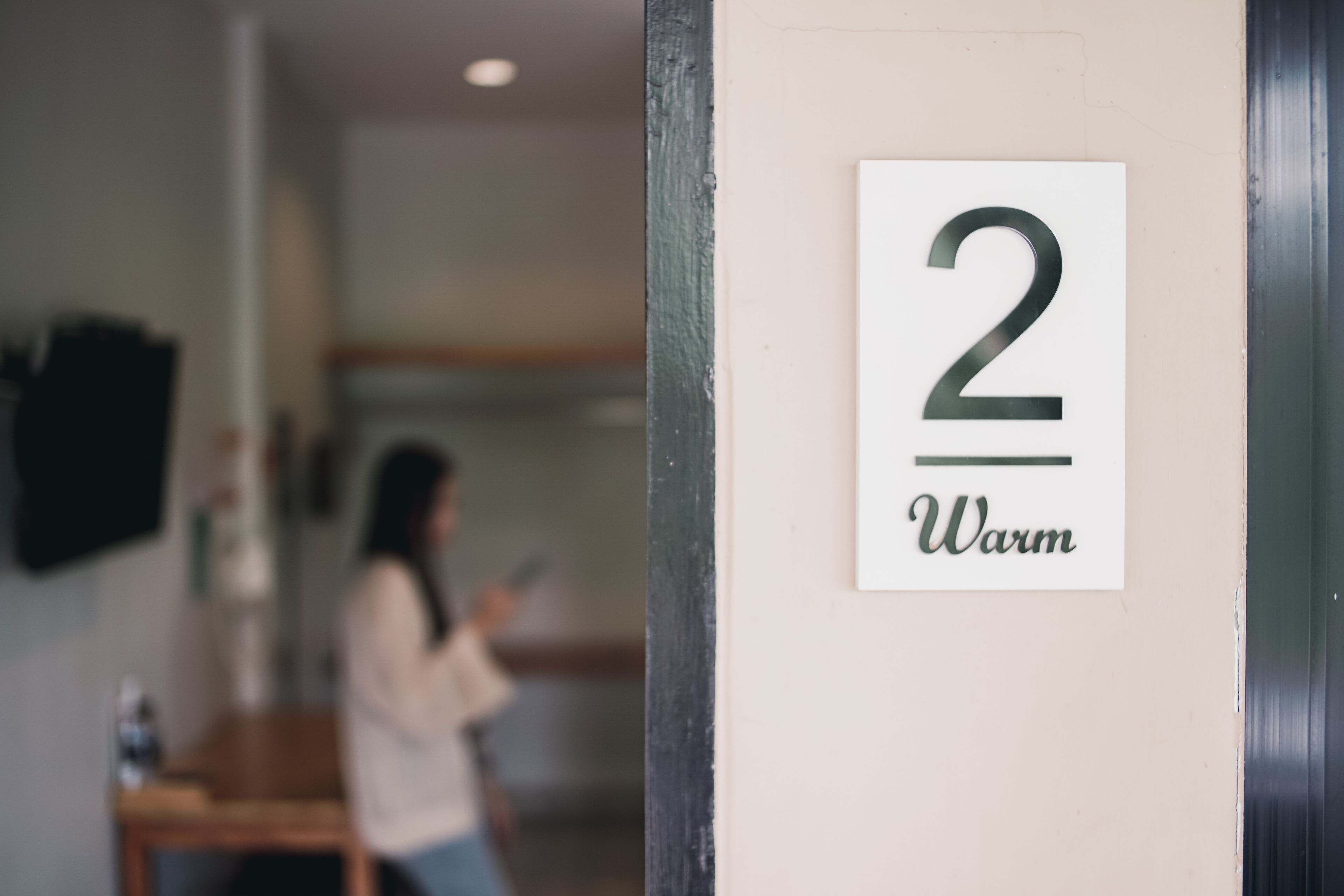 A room number sign with the number 2 and the word "Warm" on a wall.