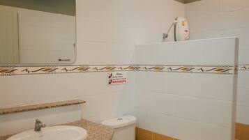 Une salle de bain avec un lavabo, des toilettes et un miroir.
