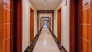A long, narrow hallway with wooden doors numbered 316 and 317. - Le Roi Jammu (Jammu)
