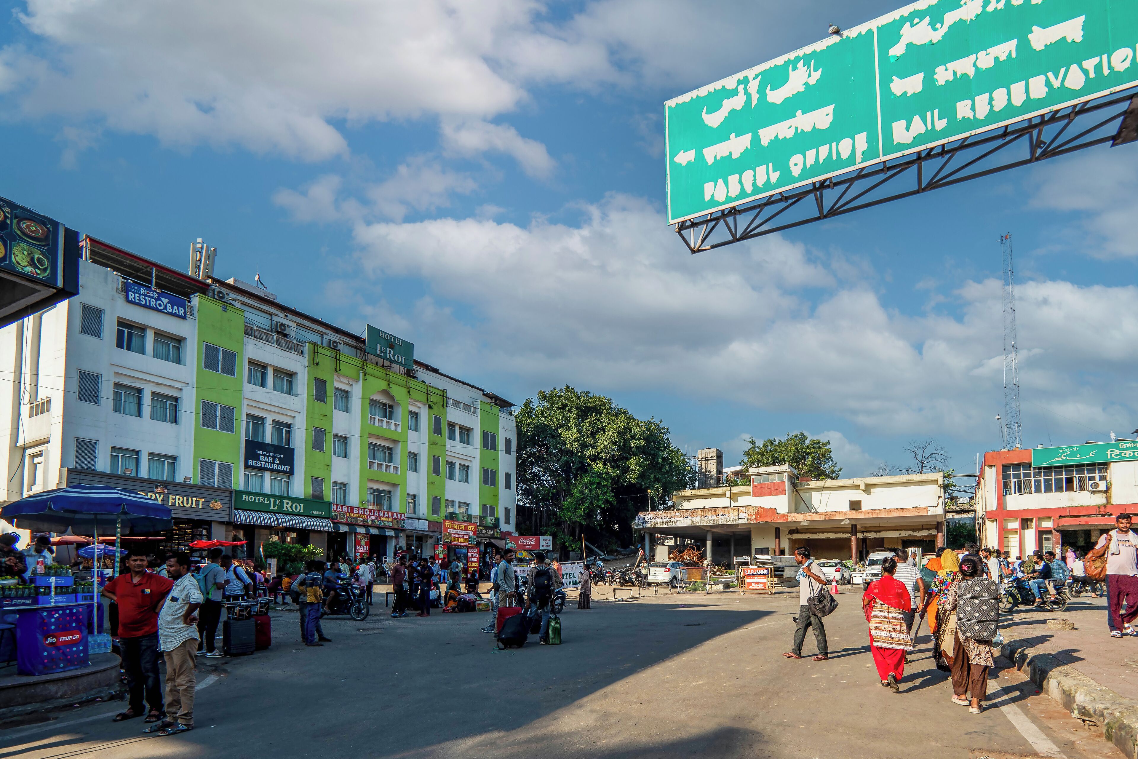 A busy street with a hotel and various shops.