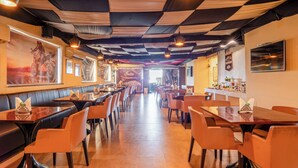 A restaurant interior with booths and tables, checkered ceiling, and wall-mounted decorations. - Le Roi Jammu (Jammu)