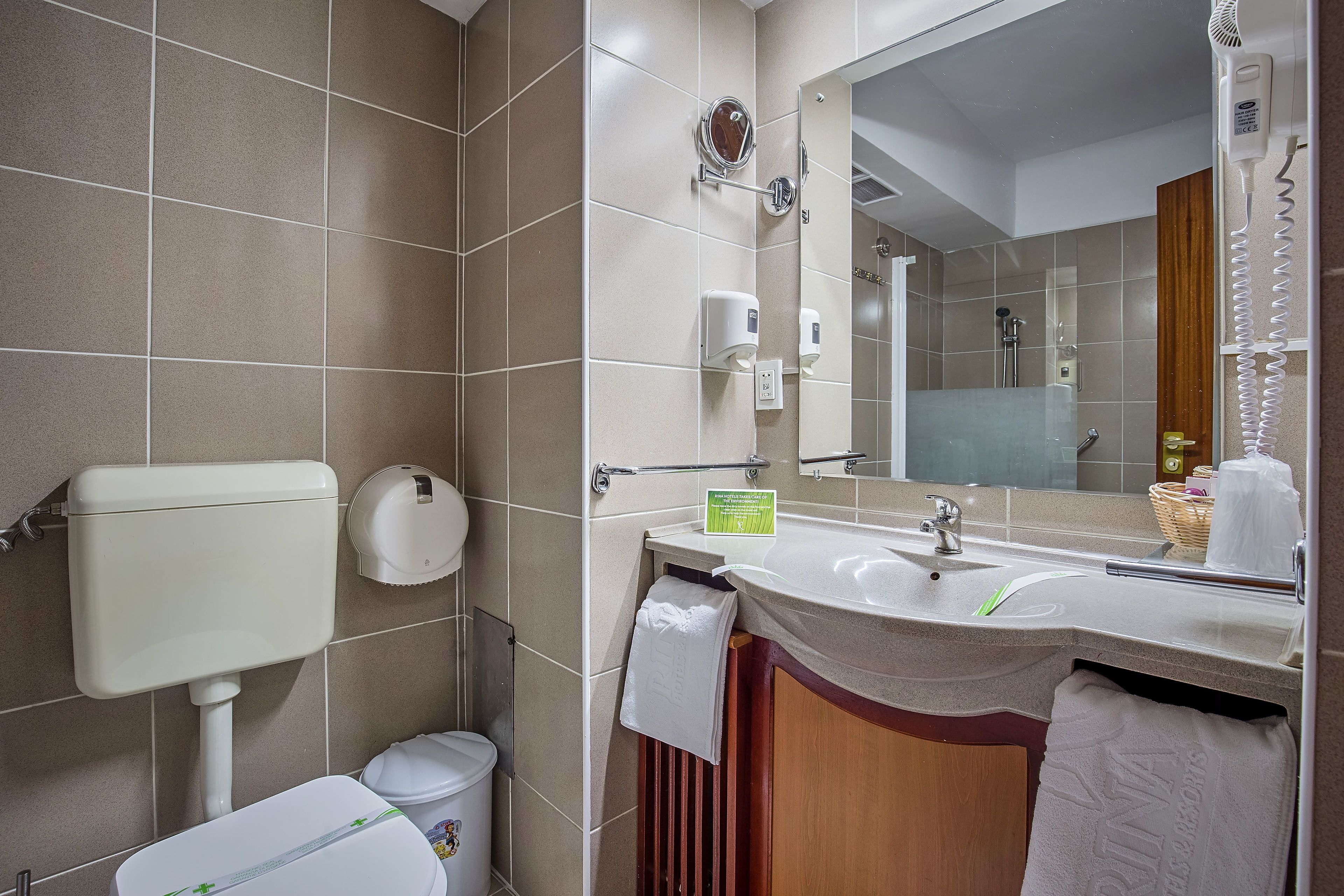 Un baño moderno con inodoro, lavabo y espejo.