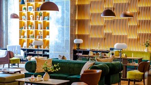 A modern interior with a green sofa, wooden shelves, and pendant lighting. - Hotel Sinaia (Sinaia)