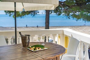 Une table en bois, un seau en métal, deux coupes de champagne et une assiette de hors-d'œuvre.