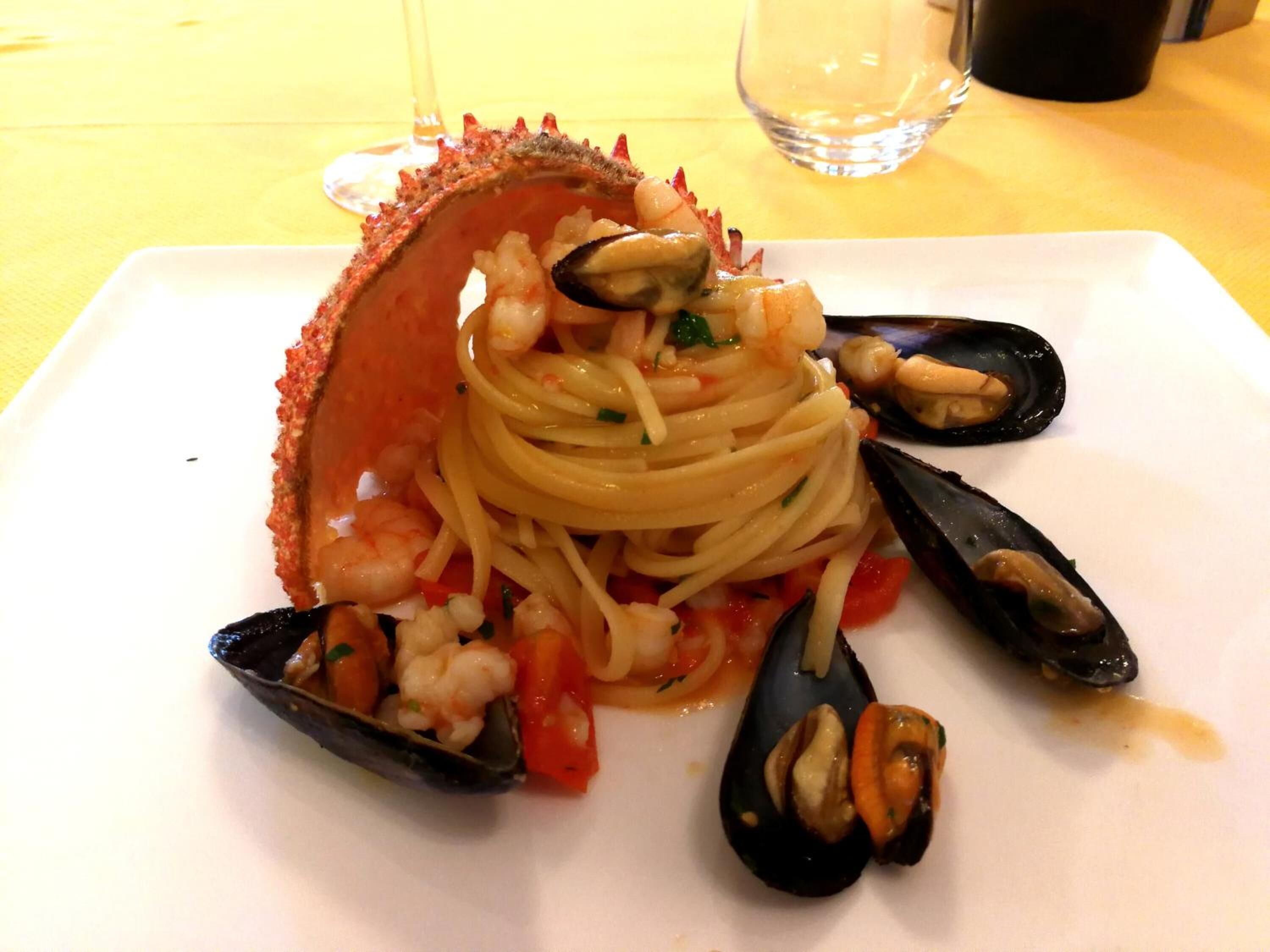A plate of seafood pasta with mussels and shrimp, served on a white plate.