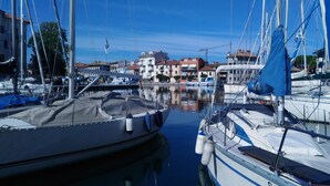 Un puerto deportivo con varios veleros amarrados, rodeado de edificios residenciales.