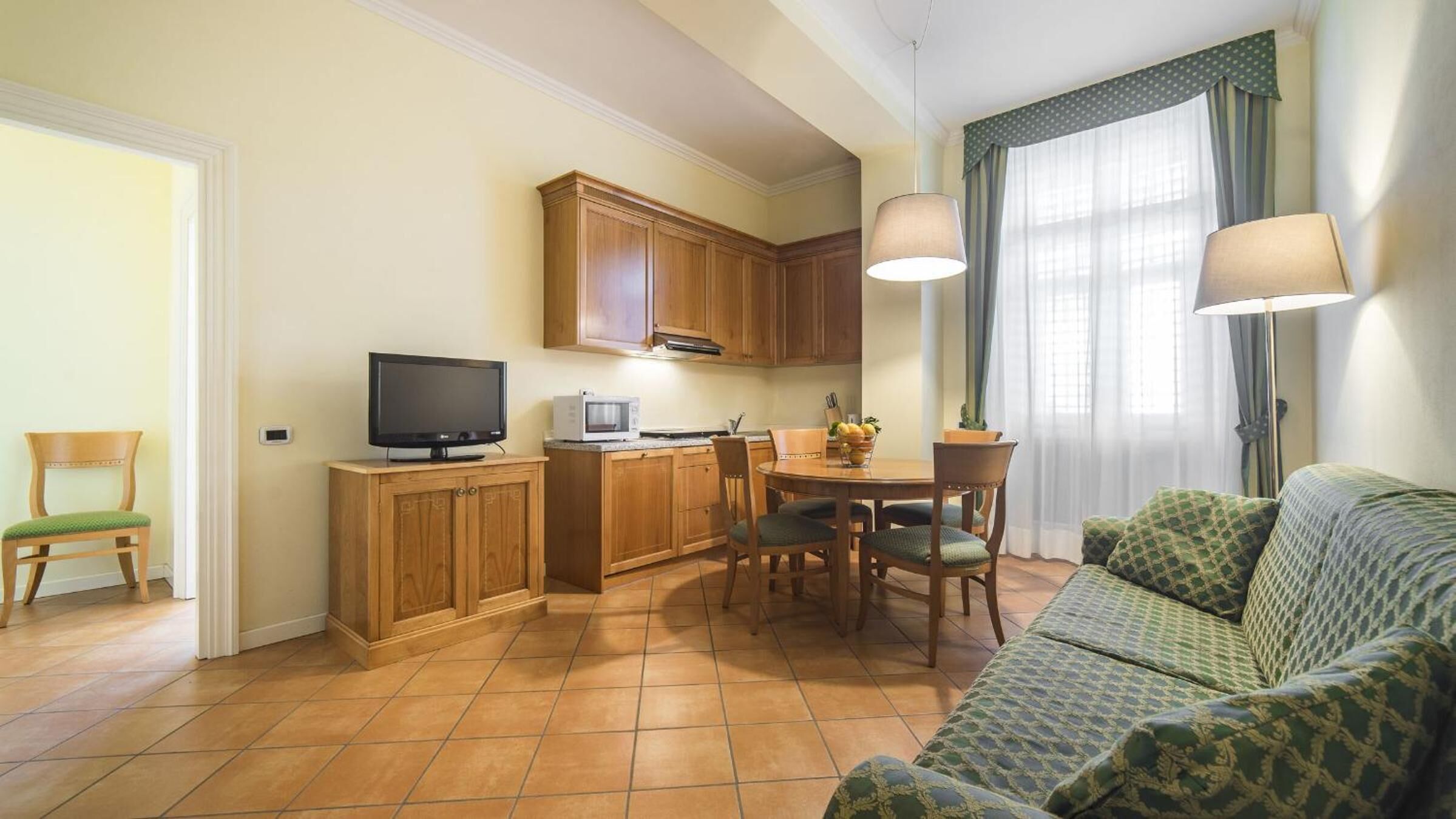 Un espacio habitable compacto con kitchenette, comedor y sofá.