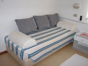 Habitación triple Confort | Área de sala de estar | Televisión 