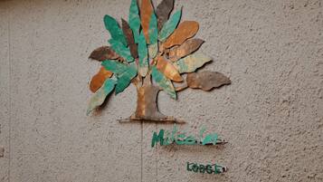 Una escultura de árbol montada en la pared con el nombre "Mecalina" y la palabra "Lodge" escritas debajo.