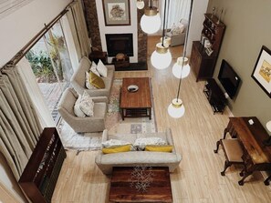 A spacious living room with a sofa, coffee table, and hanging lights. - Malcolm Lodge (Harare)