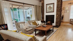 A cozy living room with a fireplace, comfortable seating, and a bookshelf. - Malcolm Lodge (Harare)