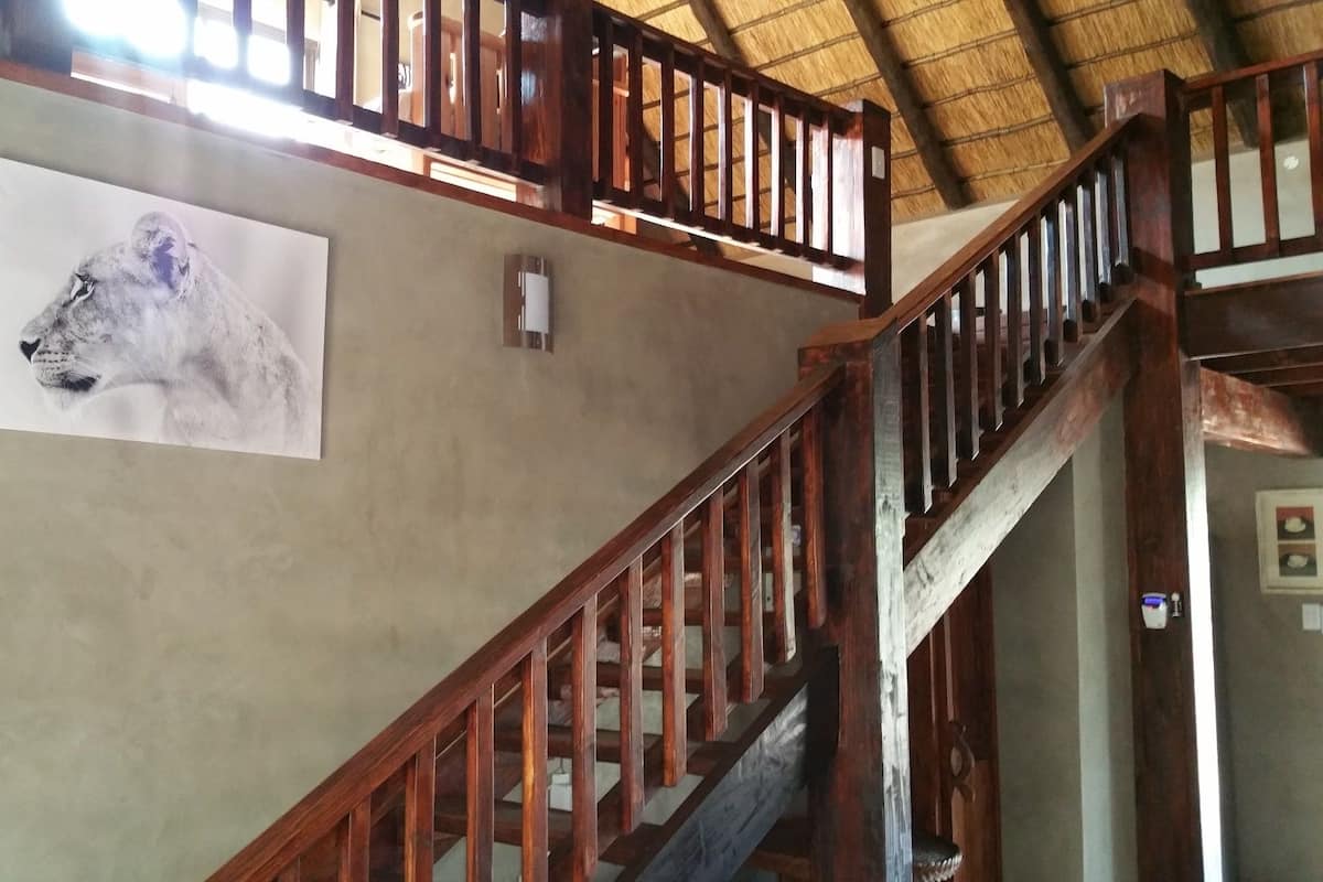A staircase with wooden railings and a ceiling with a thatched roof.