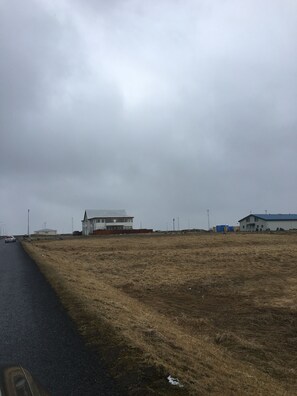 Ein Gebäude mit Flachdach und einer großen offenen Fläche davor.