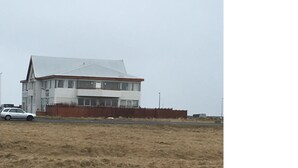 Een gebouw met twee verdiepingen, een plat dak en een groot raam op de begane grond.