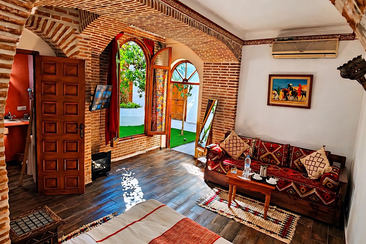 A spacious room with a wooden floor, a sofa, a coffee table, and a painting on the wall.