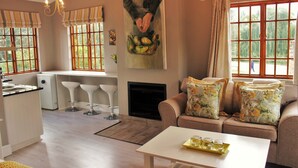 Una cocina moderna con comedor, chimenea y sofá con cojines estampados.